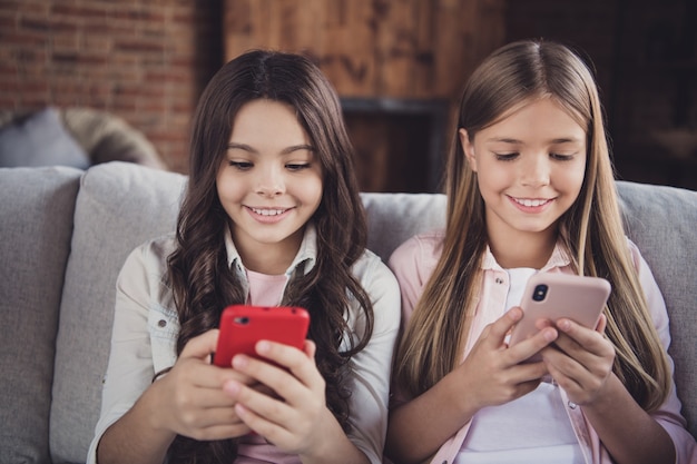 Kleine Schwestern posieren zusammen auf der Couch