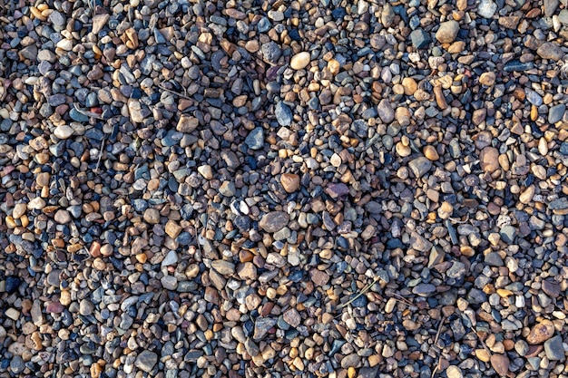 Kleine Steine Schotter auf dem Lauf des Meeres als Hintergrund