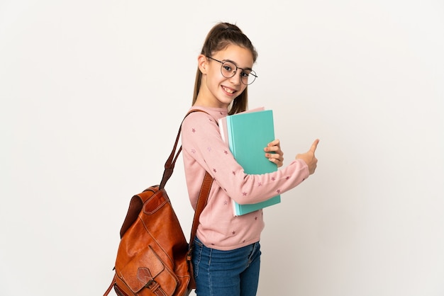 Kleine Studentin über isolierter Wand, die zurück zeigt