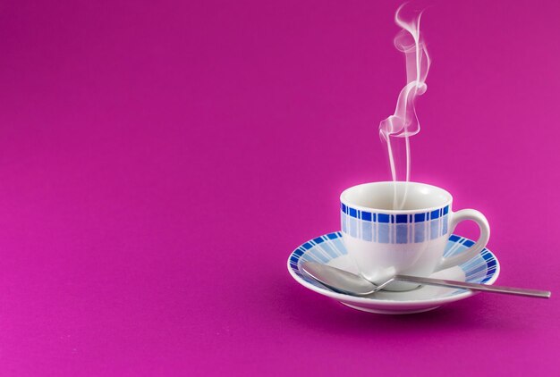 Kleine Tasse Kaffee auf farbigem Hintergrund
