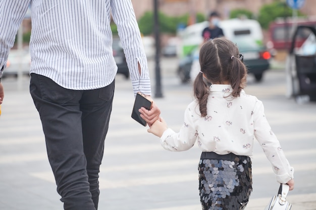 Kleine Tochter und Vater gehen in der Stadt.