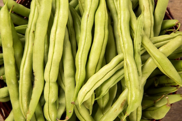 Foto kleine und schlanke grüne bohnen (haricot vert) auf einem holz. frisches gemüse.