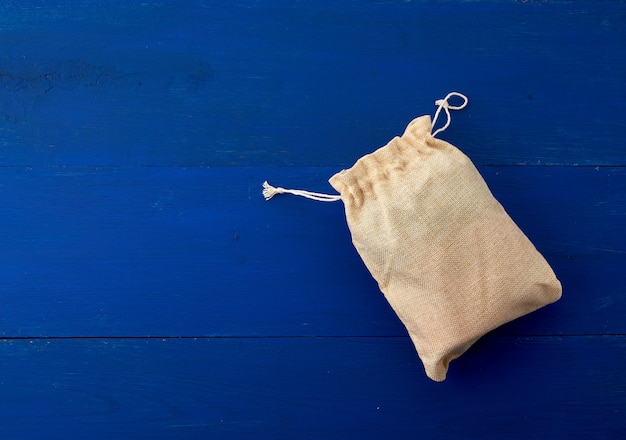 Kleine volle Segeltuchtasche mit Bindungen, blauer hölzerner Hintergrund