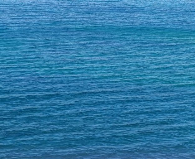 Kleine Wellen auf dem blauen Meerwasser Naturhintergrund Reiseurlaub