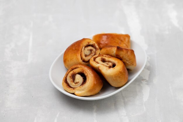 Kleine Zimtbrötchen auf einem weißen Teller