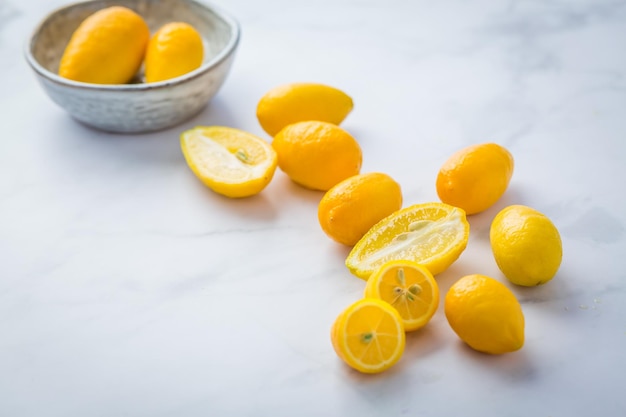 Kleine Zitrusfrüchte Limequat mit Schüssel auf dem Tisch