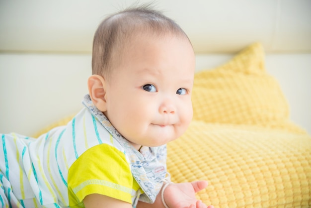 Foto kleiner asiatischer süßer junge, der auf den boden legt.