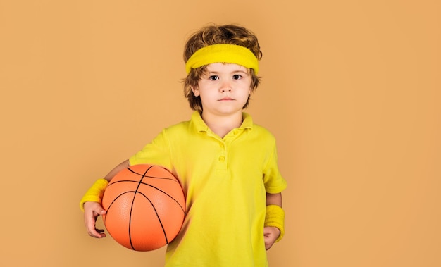 Kleiner Basketballspieler mit Basketballball, sportliches Kind, Junge in Uniform, der Basketball spielt