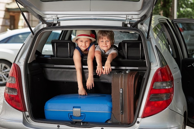 Kleiner Bruder und Schwester, die hinten in einem Auto sitzen