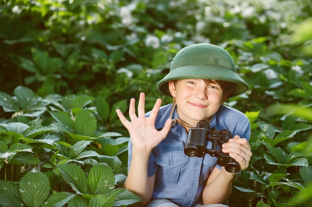 Kleiner Entdecker mit Fernglas im Wald