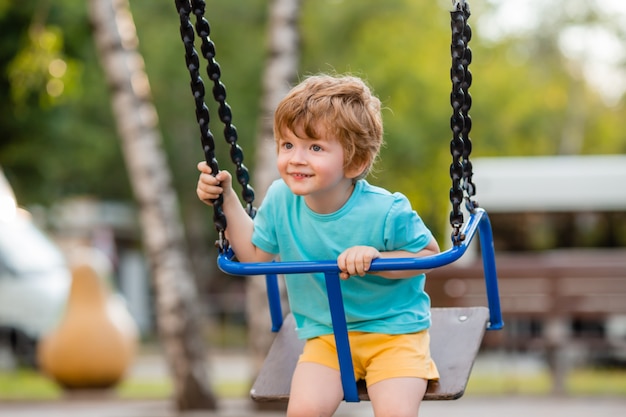 Kleiner fröhlicher Junge auf dem Spielplatz