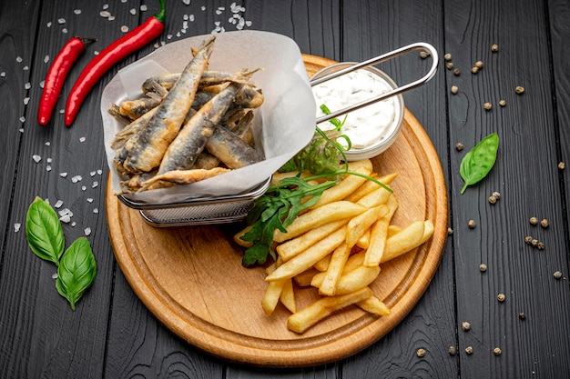 Kleiner gebratener Fisch und Pommes Frites in einem Restaurant am Meer Gebratene Sardellen