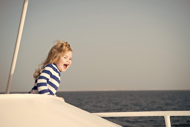 Kleiner glücklicher kleiner Junge, Kapitän der Yacht im Marinehemd