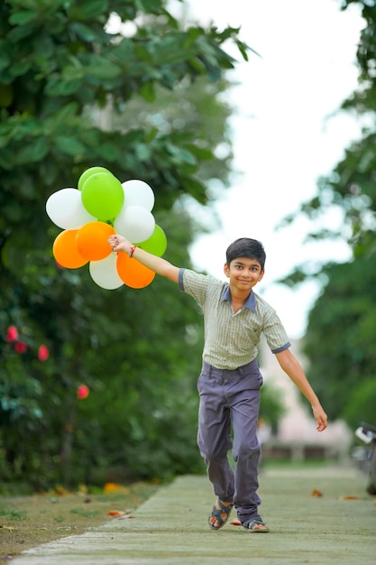 Kleiner indischer Junge mit dreifarbigen Luftballons