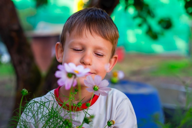 Kleiner Junge auf dem Hintergrund von Blumen