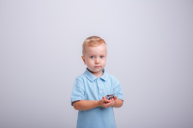 Kleiner Junge auf weißem Hintergrund in einem Studio mit blauem Hemd