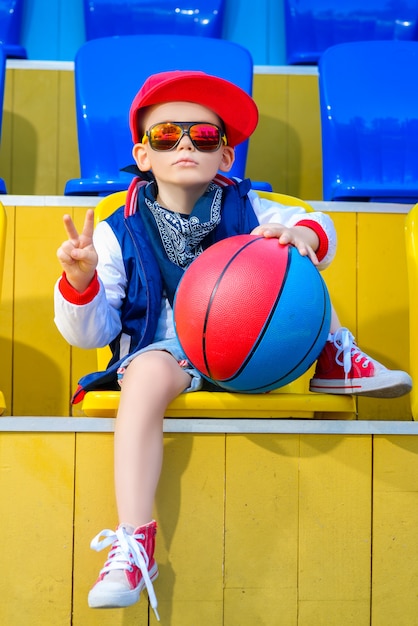 kleiner Junge, der am Basketballplatz aufwirft.