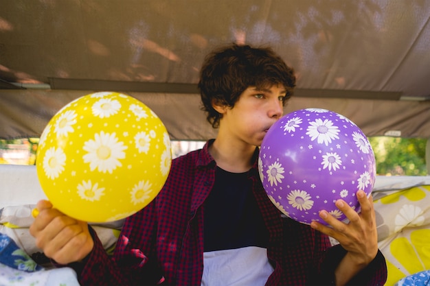 Kleiner Junge, der am Wochenende im Freien in den Ballon bläst