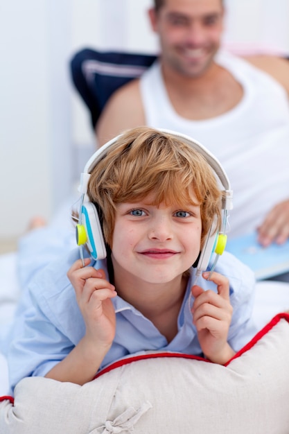 Kleiner Junge, der an Musik im Schlafzimmer mit Kopfhörern hört