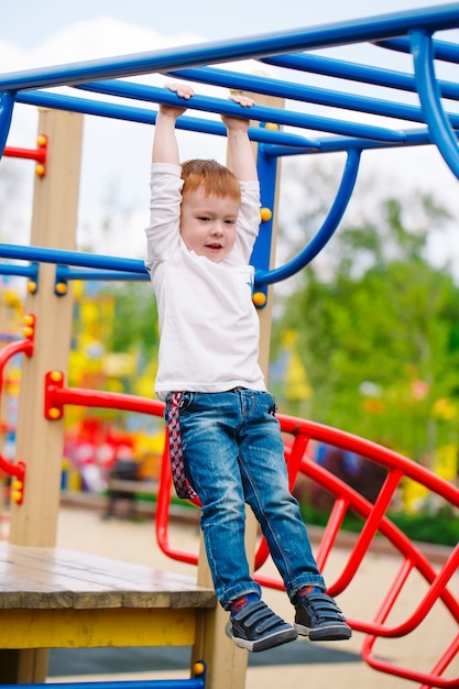 Kleiner Junge, der auf dem Spielplatz spielt.