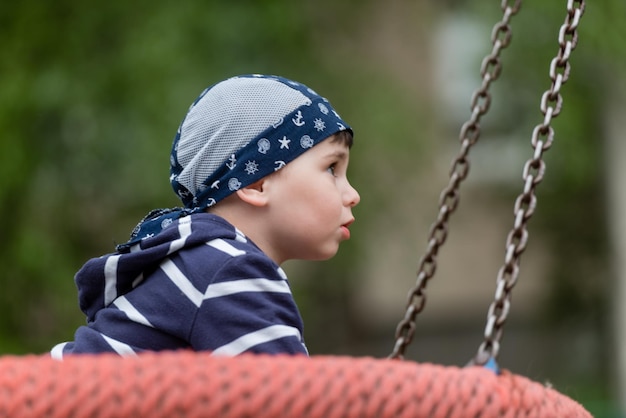 Kleiner Junge, der auf einer Schaukel reitet