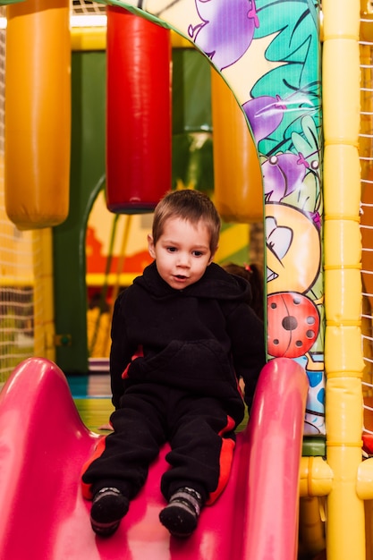 Kleiner Junge, der fröhlich im Kinderspielzimmer spielt