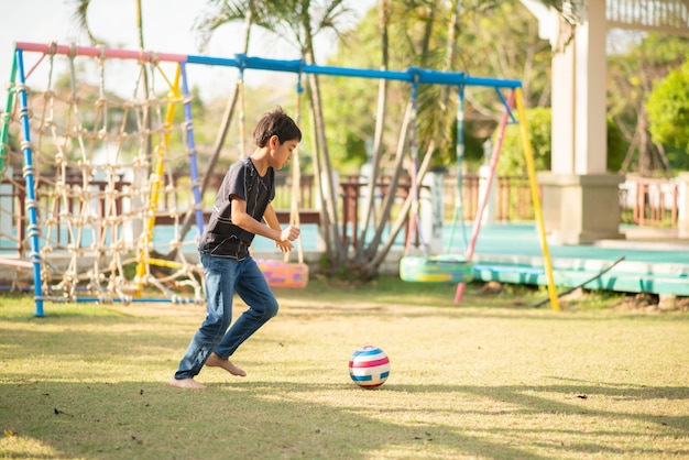 Kleiner Junge, der im Spielplatz im Freien spielt