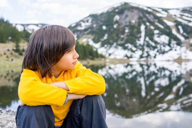 Kleiner Junge, der in den Ferien zum Berg genießt