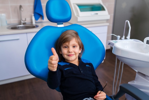 Foto kleiner junge, der in der zahnarztpraxis lächelt
