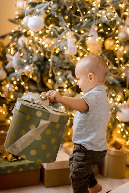 Kleiner Junge, der in Weihnachtsdekorationen spielt