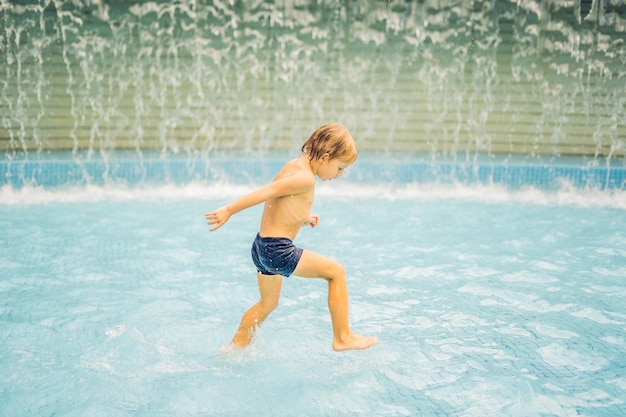 Kleiner Junge, der Spaß beim Laufen im Schwimmbad hat