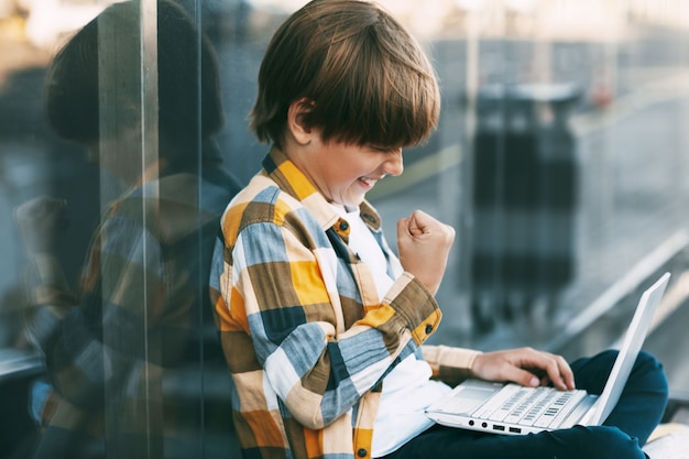 Kleiner Junge, der über seinen Computer kommuniziert