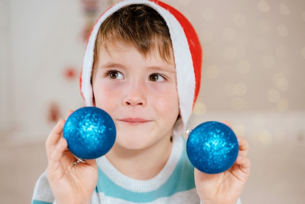 Kleiner Junge, der Weihnachtsschmuck hält