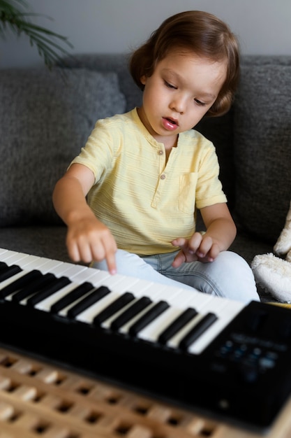 Foto kleiner junge, der zu hause tastatur spielt