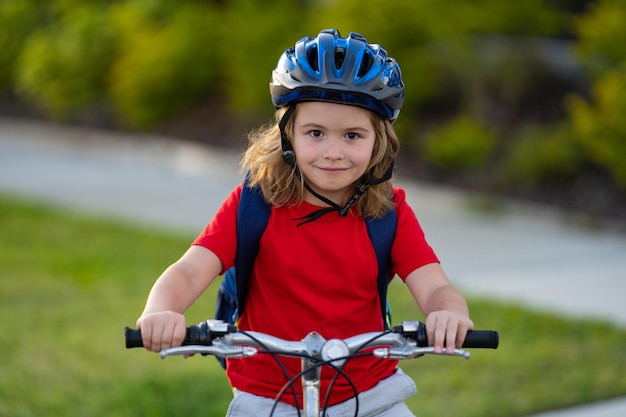 Kleiner Junge fährt Fahrrad im Park, Kind radelt auf dem Fahrrad, glücklich lächelndes Kind mit Helm