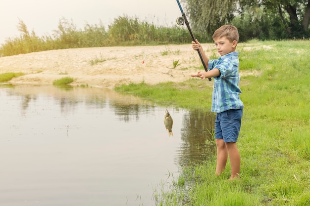 Kleiner Junge fischt am Fluss