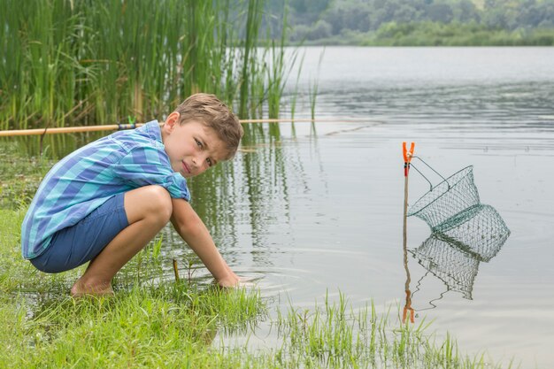 Kleiner Junge fischt am Fluss