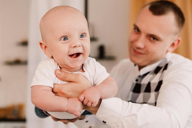 Kleiner Junge glücklich lustig lächelnd lachend süßes Kind Baby, Vater hält das Kind hoch