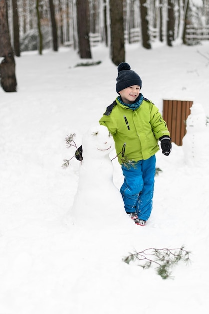 Kleiner Junge hat Spaß beim Spielen mit Schnee