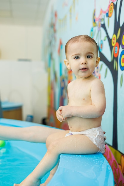 Kleiner Junge im Alter von 2 Jahren ist im Pool Schwimmunterricht für kleine Kinder