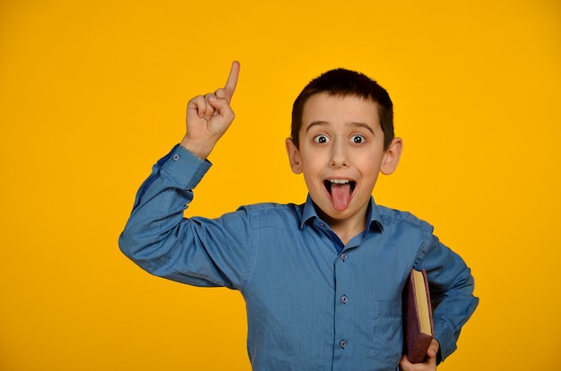 Foto kleiner junge im blauen hemd macht lustiges gesicht