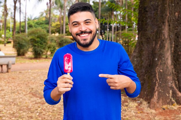 Kleiner Junge im Park mit einem Eis am Stiel, um sich abzukühlen