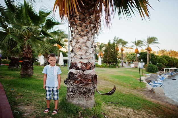 Kleiner Junge im Türkei-Resort gegen Palmen