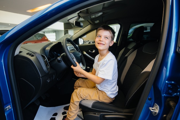 kleiner Junge in einem Auto im Autohaus