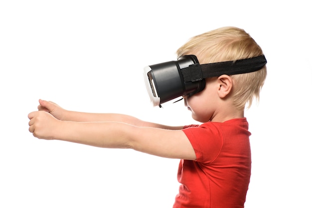 Kleiner Junge in einem roten Hemd erlebt virtuelle Realität, die Hände vor ihm hält. Auf Weiß isolieren. Technologiekonzept