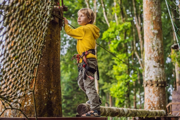 Kleiner Junge in einem Seilpark Aktive körperliche Erholung des Kindes an der frischen Luft im Park Training für Kinder