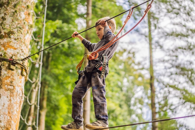 Kleiner Junge in einem Seilpark Aktive körperliche Erholung des Kindes an der frischen Luft im Park Training für Kinder