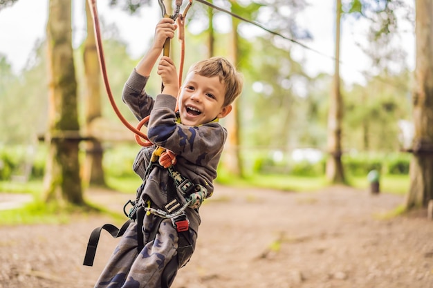 Kleiner Junge in einem Seilpark Aktive körperliche Erholung des Kindes an der frischen Luft im Park Training für Kinder