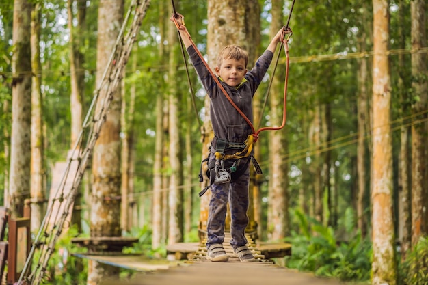 Kleiner Junge in einem Seilpark Aktive körperliche Erholung des Kindes an der frischen Luft im Park Training für Kinder