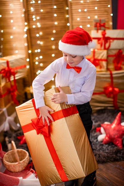 Kleiner Junge in einem weißen Hemd und Weihnachtsmannmütze